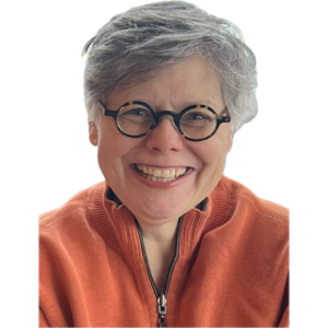 Shannon Boston smiling in an orange sweater and glasses, with a bright background.