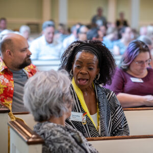 Congregants engage in conversation before a service at All Souls Unitarian Church, fostering connection and community.