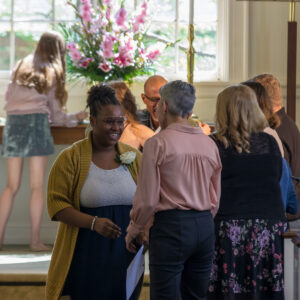 A joyful participant of the Coming of Age ceremony being congratulated at All Souls Unitarian Church.