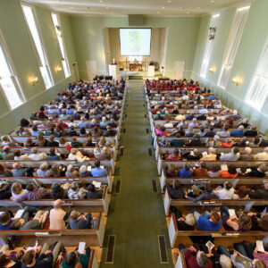 A packed sanctuary during a service at All Souls Unitarian Church, viewed from the balcony.