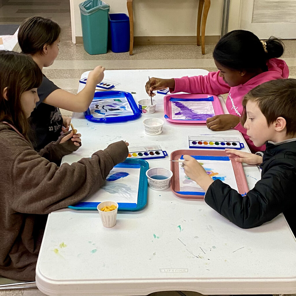Children engage in painting activities in the Presidents Room, expressing creativity through art.