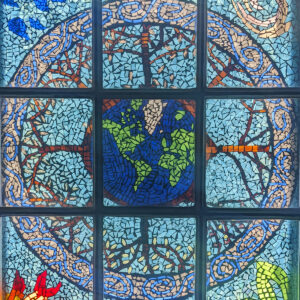 A colorful stained glass mosaic with Earth at the center.