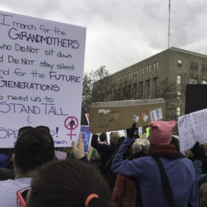 Participants at the 2017 Women's March hold signs advocating for women's rights and equality.