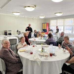 Members of the Young at Heart group at All Souls Unitarian Church enjoy lunch together, engaging in conversation and community.