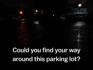 Very dark photo of the church parking lot with just a few pinpoints of light.